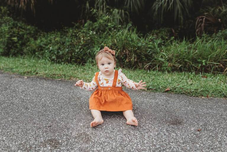 little girl sits on pavement