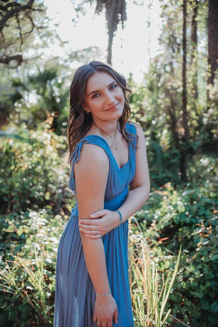 senior girl with gorgeous light coming through trees