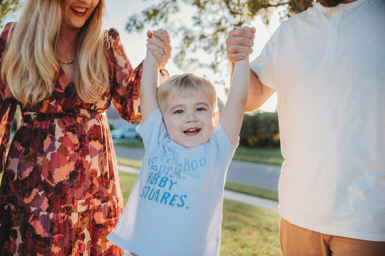 mom and dad swinging little boy